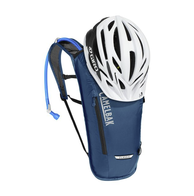 the camelbak classic lite hydration pack in navy, view of the pack with a helmet strapped to it