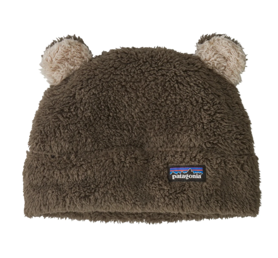 A brown Patagonia fleece beanie hat with two fluffy pom-pom ears on top and a small Patagonia logo patch on the front fold.