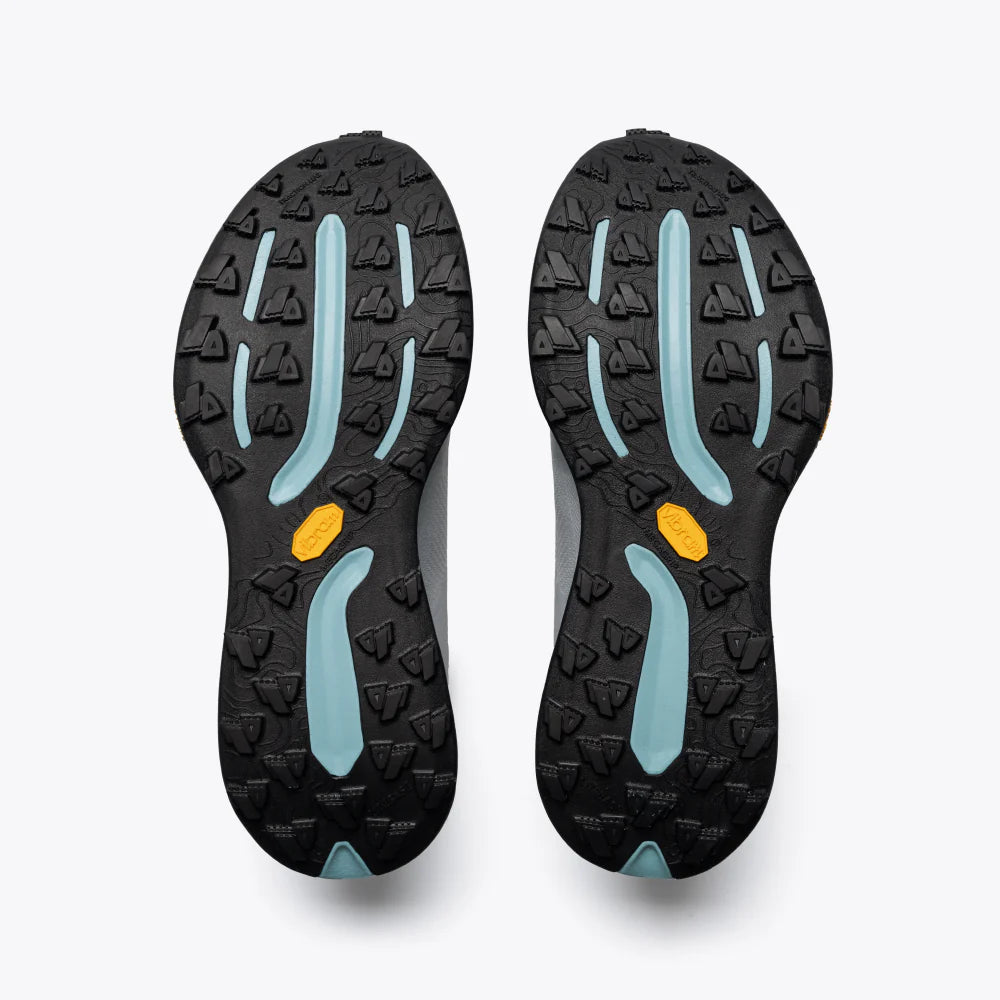 Black and blue sole of a shoe with a yellow dot on a white background