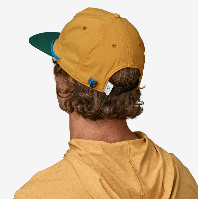 the patagonia merganzer hat in the color water people pufferfish gold, back view on a model