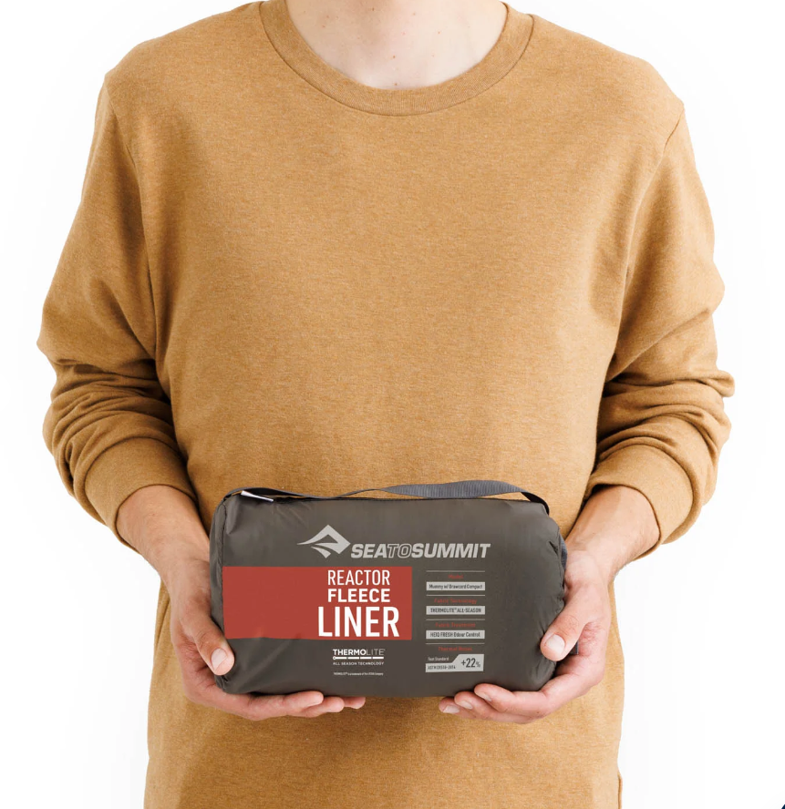 the sea to summit reactor fleece sleeping bag liner, shown in it's stuff sack