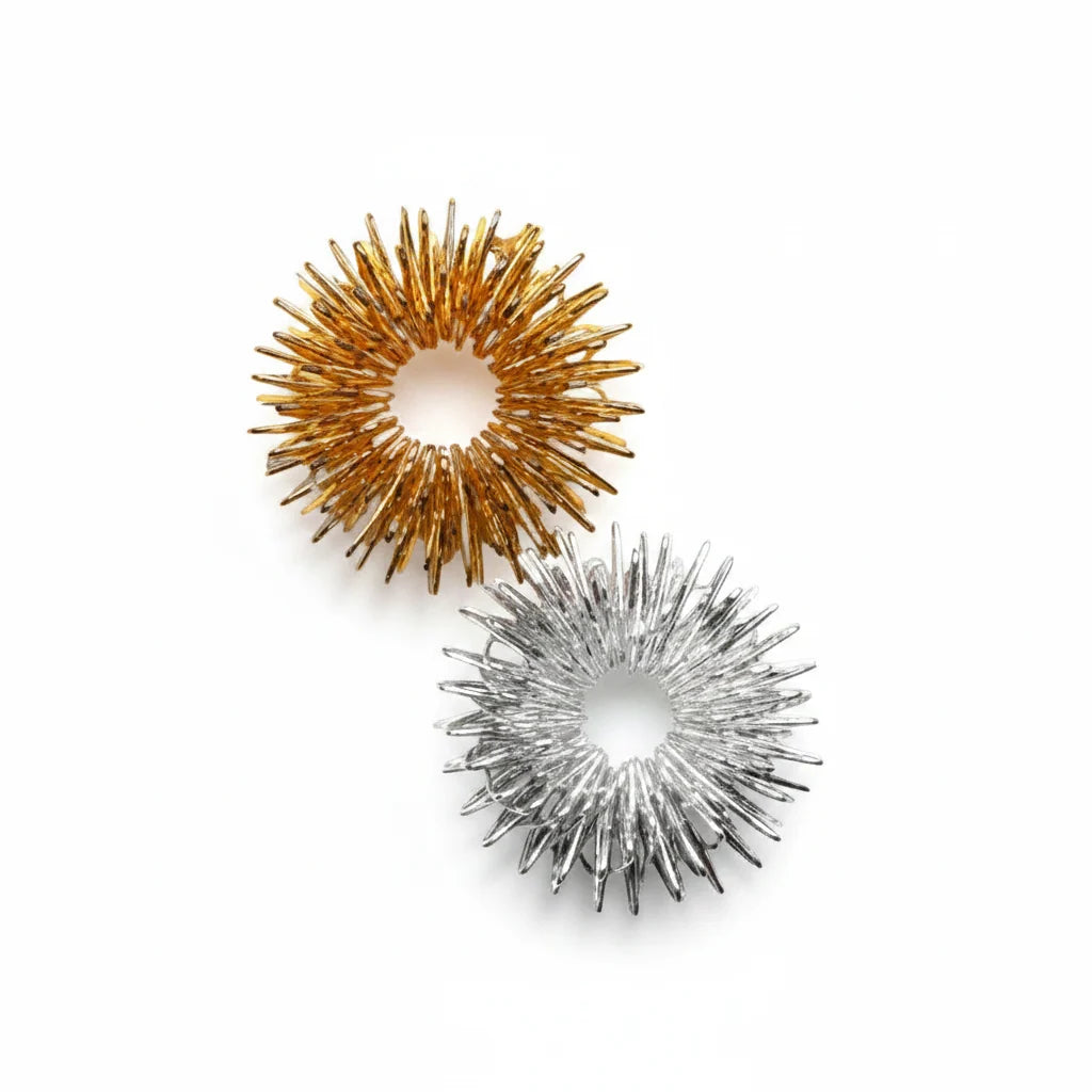 Two metallic massage rings, one in gold and one in silver, displayed on a clean white background.