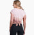 a model wearing the kuhl womens isla short sleeve shirt in the color sand, back view with the back tied