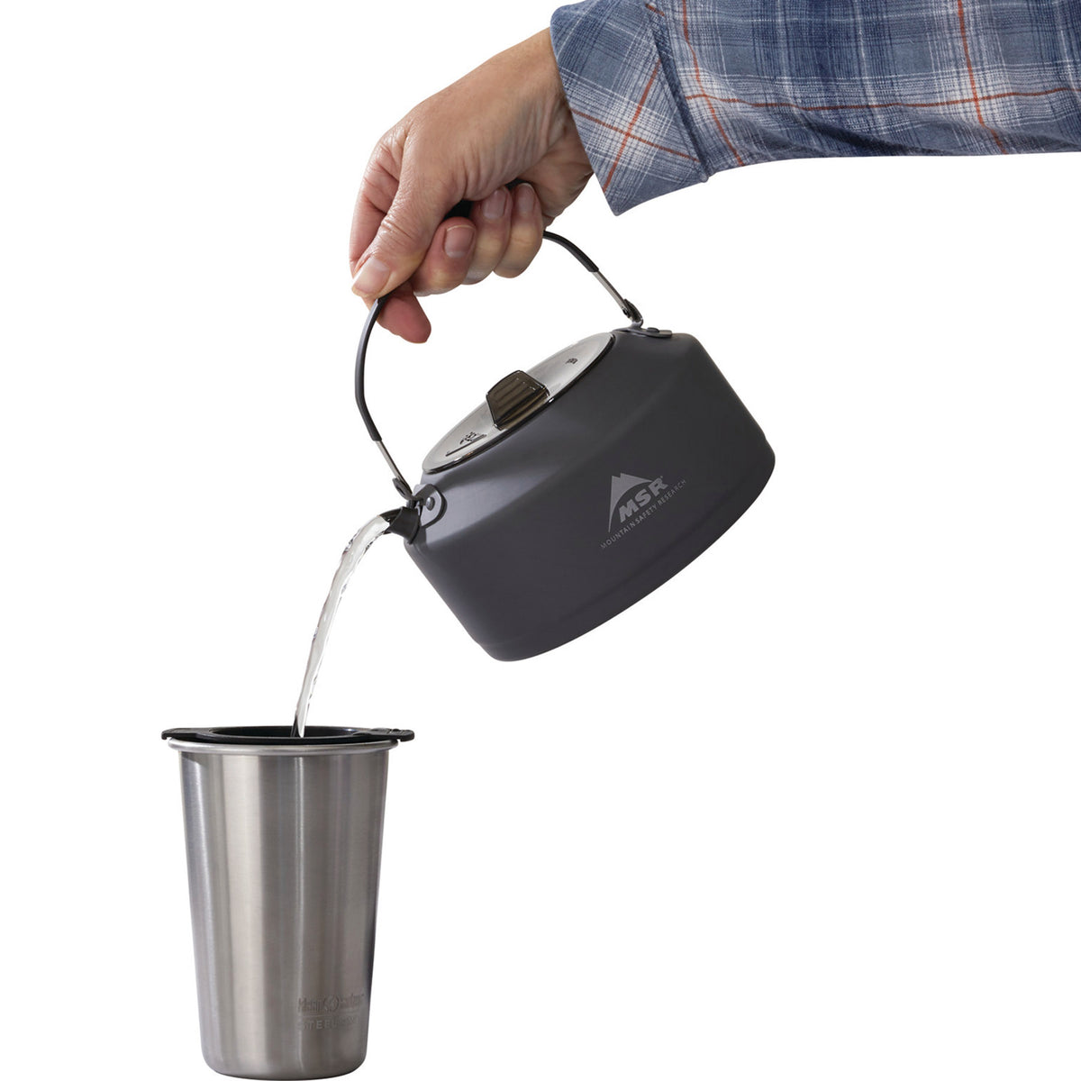 pouring water out of the pika pot, into a coffee strainer over a mug