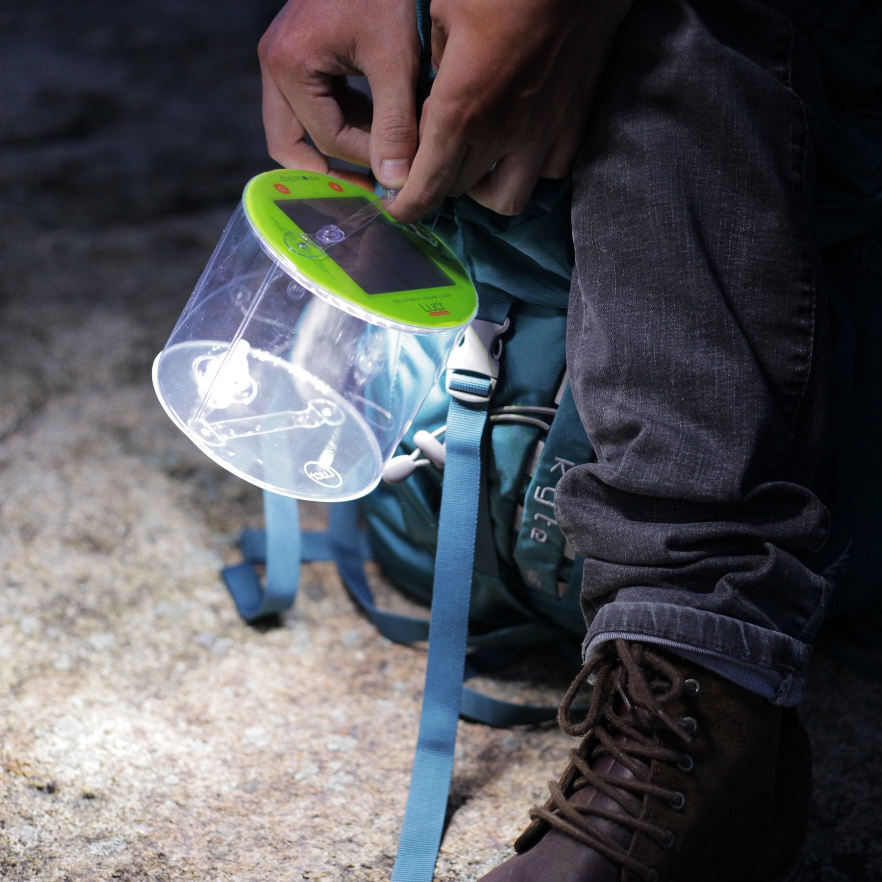 attaching a lantern to a blue backpack