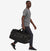patagonia 70 litre black hole duffel in black, photo with a model walking with duffel in hand