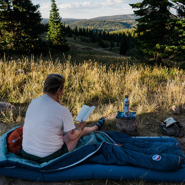a man sits on his pad, reading