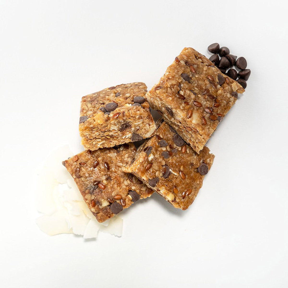 four cut up pieces of the chocolate coconut probar with some of its raw ingredients along side