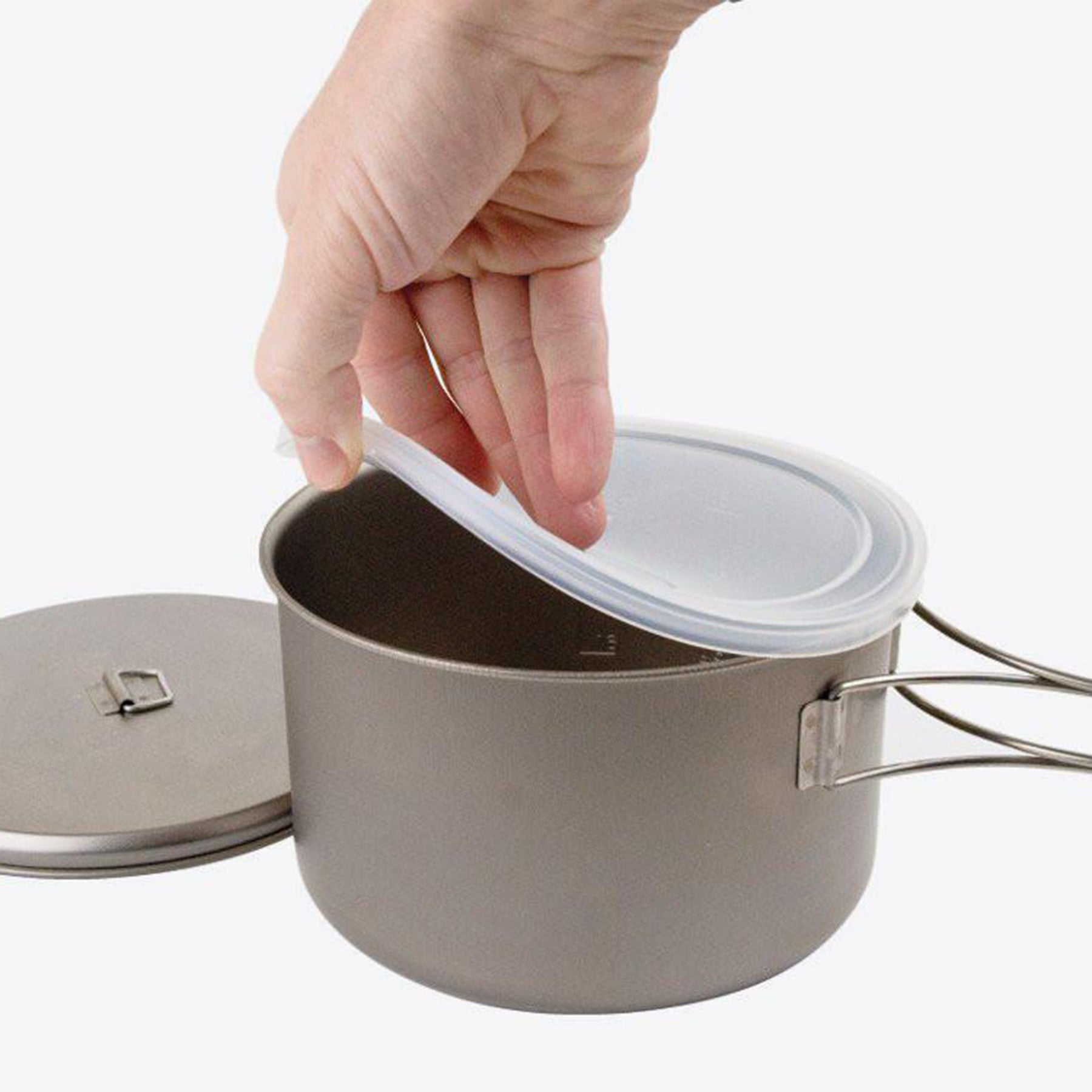 a model's hand put the plastic lid on the pot