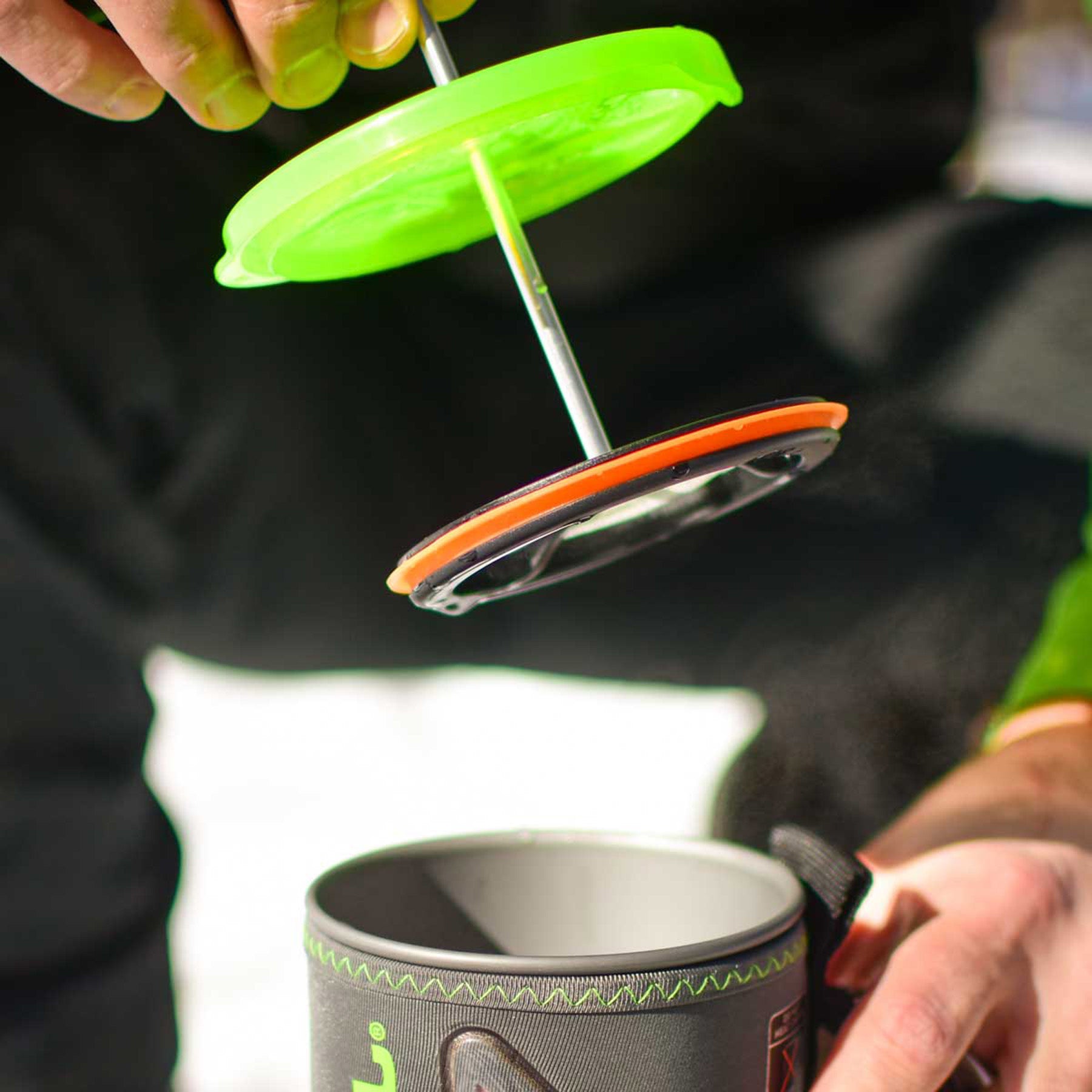 a coffee press being inserted into a jetboil pot