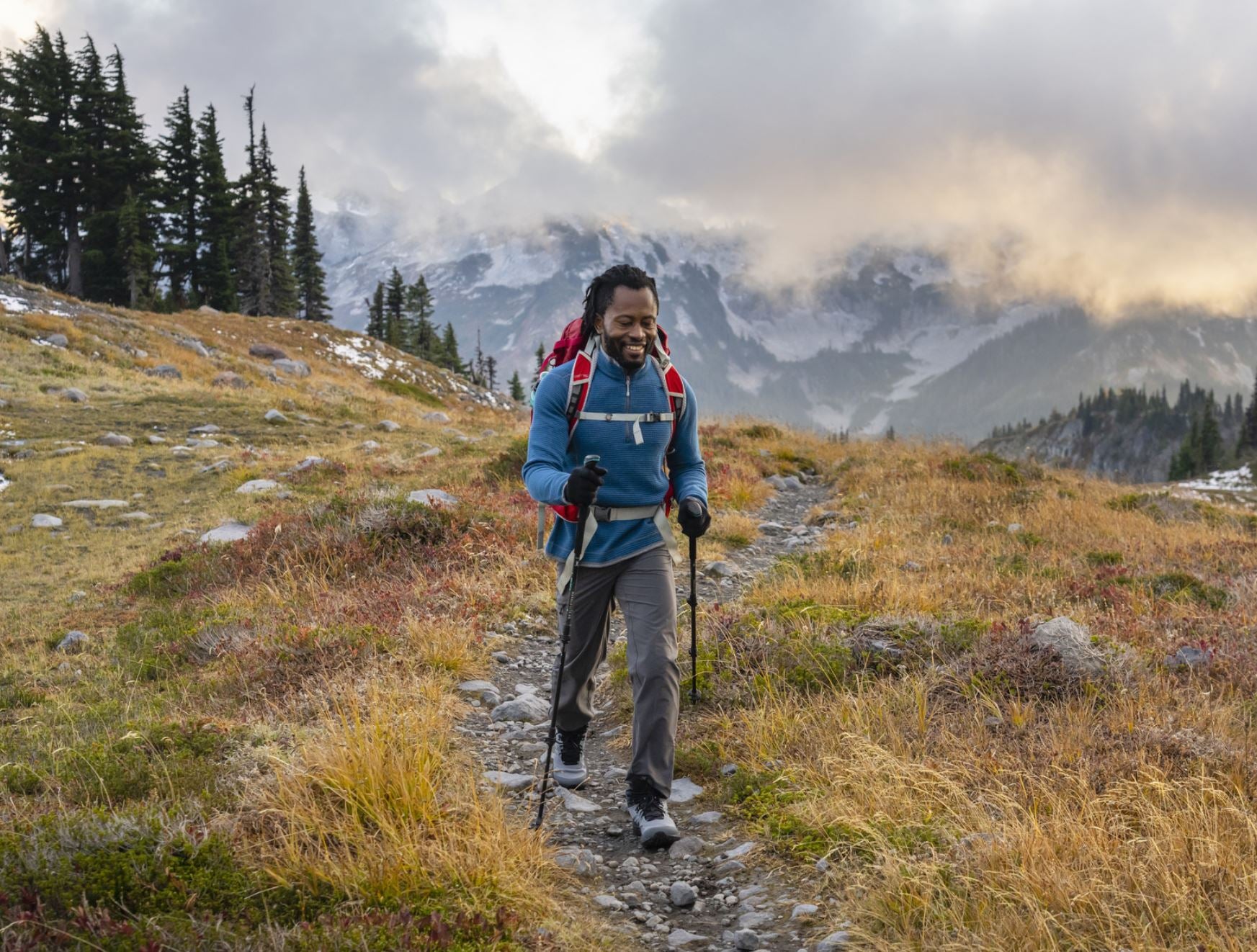 a photo of a model hiking in the topo mens trailventure 2 in stone/navy