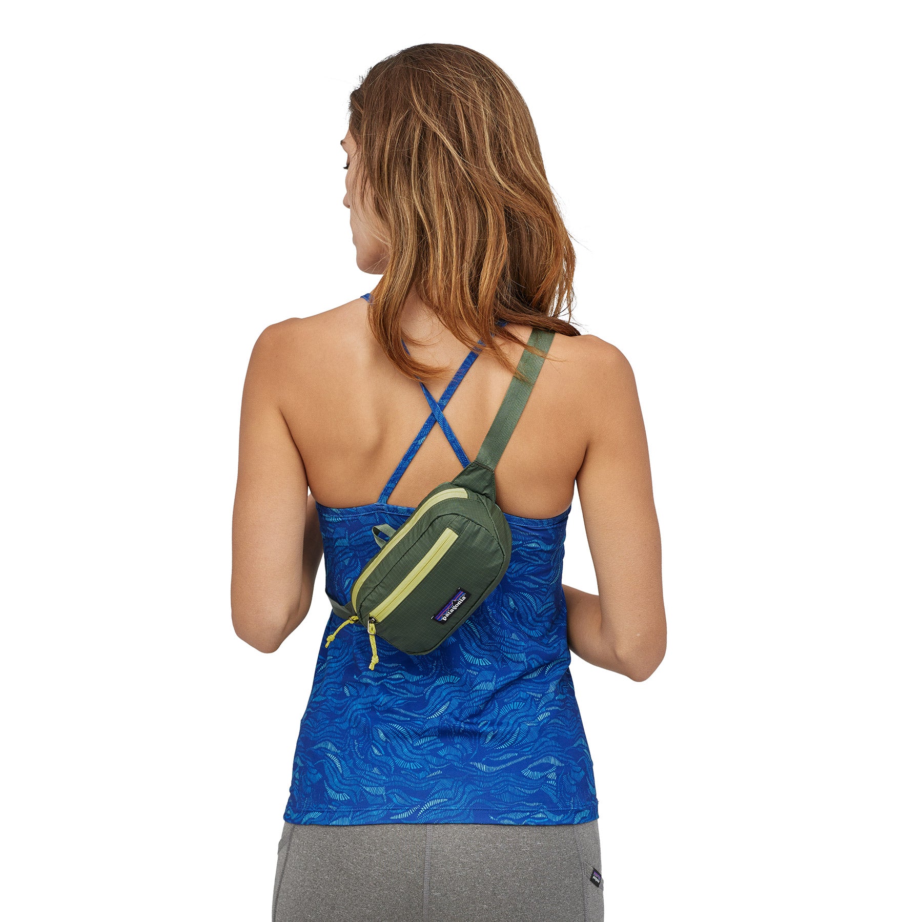 ultralight hip pack slung cross-body on live model in a green color
